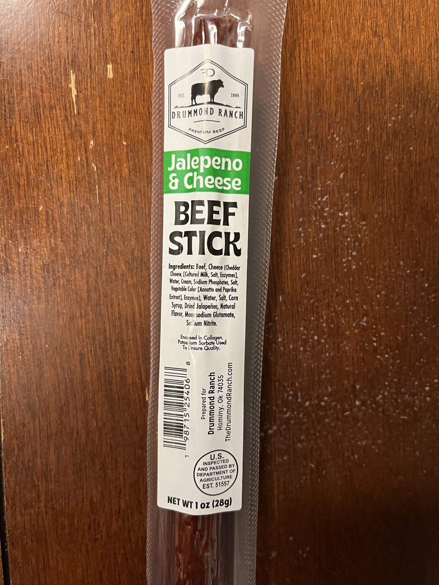 Close-up of a Jalapeño & Cheese beef stick from Drummond Ranch in its packaging, listing ingredients and branding on the label.