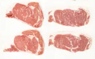 A variety of raw beef cuts from Drummond Ranch displayed in neat rows on a white background, showcasing differences in marbling and shape.
